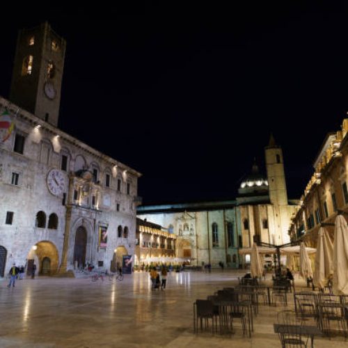 Ascoli Piceno, Italy - June 8, 2021: Ascoli Piceno, Marche, Italy: historic buildings by night. Piazza del Popolo, the main square of the city